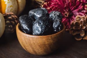 Bol d'Obsidienne noire avec des fleurs d'automne. Une des histoires de cette pierre, remonte avant 7 000 ans avant Jésus-Christ, elle était utilisée pour accomplir des actes chirurgicaux, car elle possède un tranchant efficace. Elle est le symbole de nombreuses vertus.